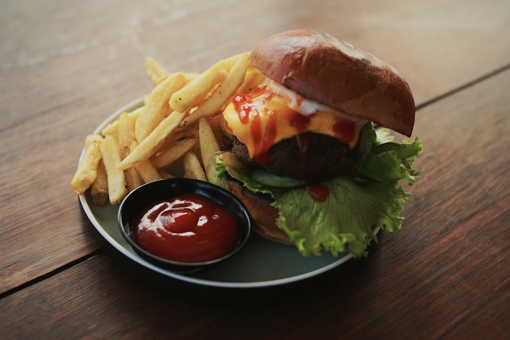 burger and fries with ketchup served on plate