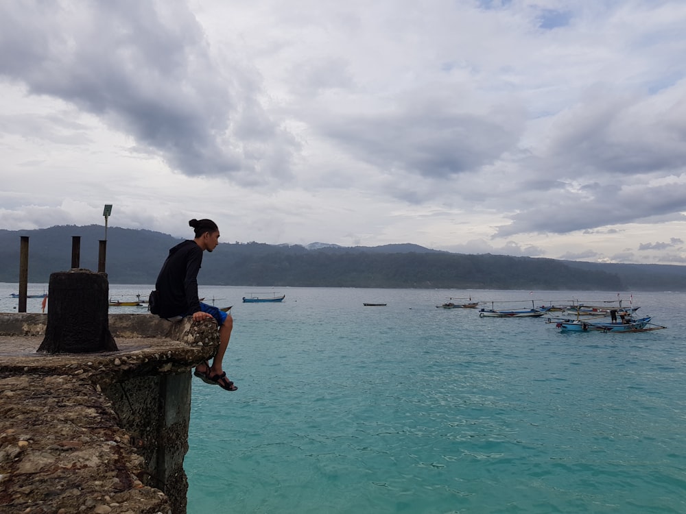 man sitting near ocean