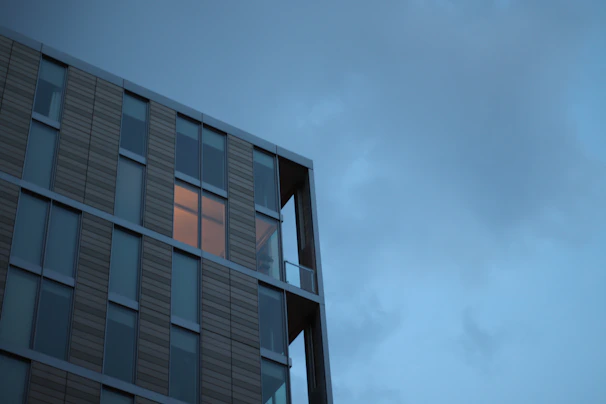 A sleek office building with solar panels and IoT sensors glowing softly at dusk.