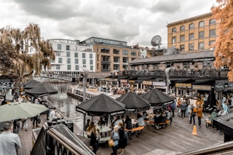 people sitting at tables near dock during daytime