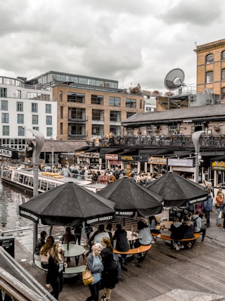 people sitting at tables near dock during daytime