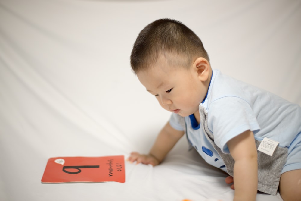 baby sits near textile