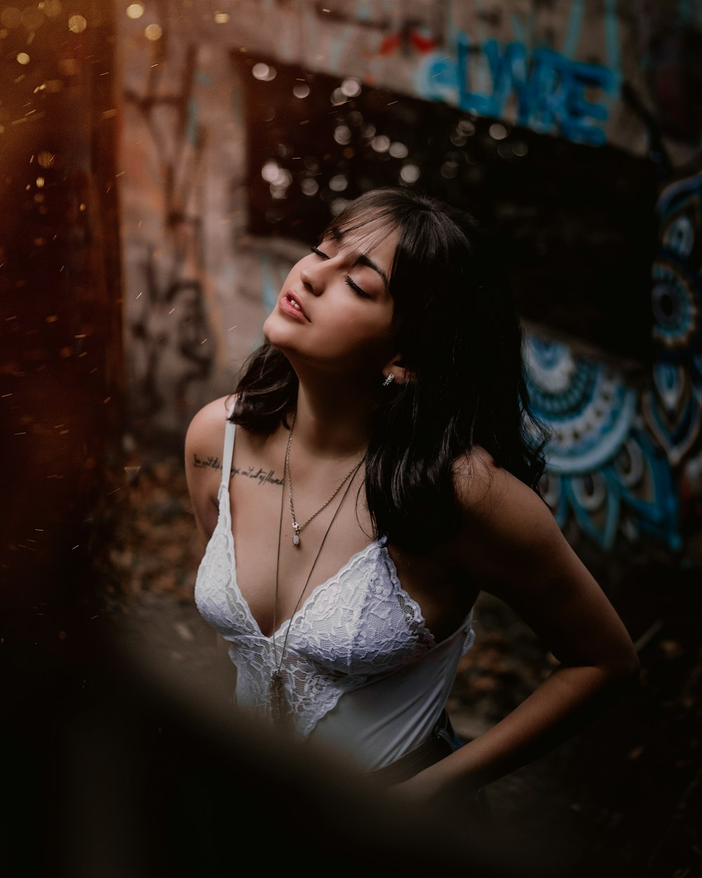 woman in white tank top standing near building