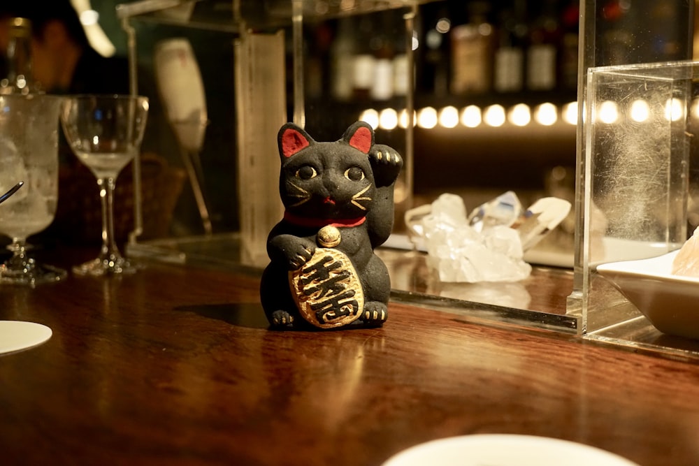 Manikeniko cat figurine on brown wooden surface