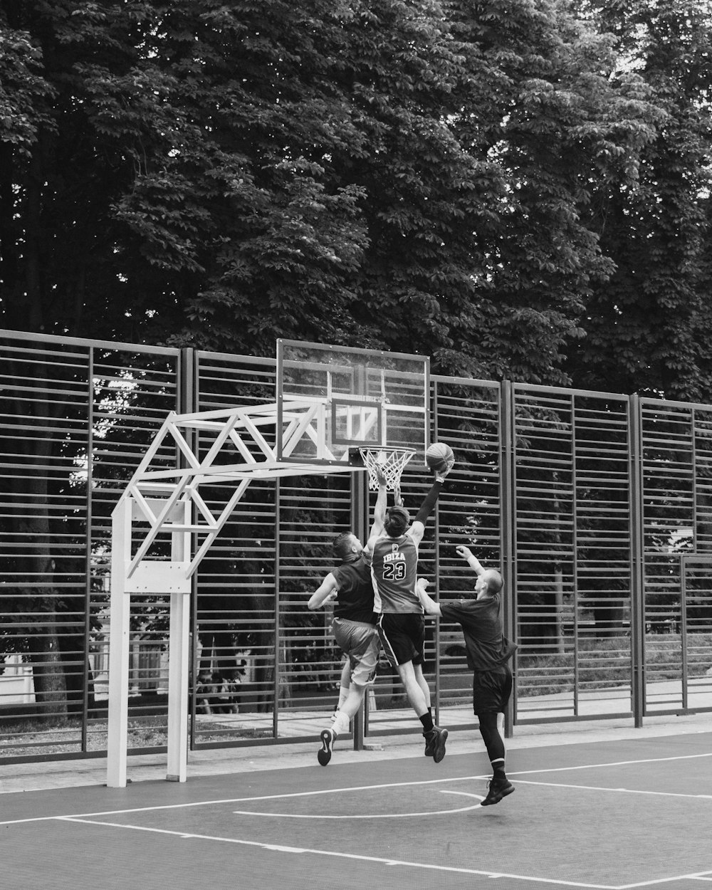 greyscale photography of people playing basketball