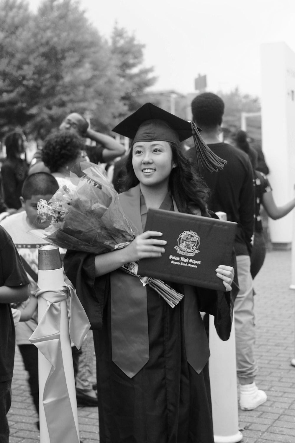 grayscale photo of girl wearing graduation gown