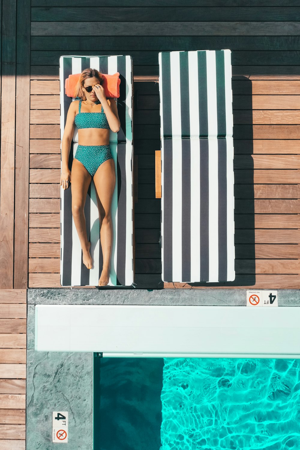Frau im Bikini liegt auf Poolliege