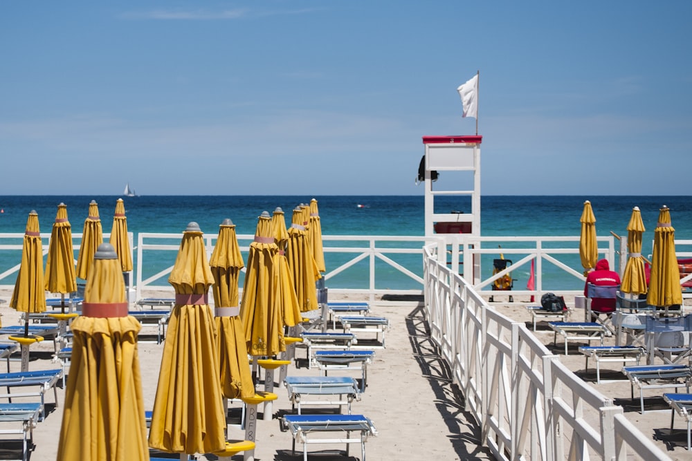 sedie a sdraio con ombrelloni in spiaggia durante il giorno