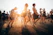A colorful outdoor music festival scene with happy people enjoying music, games, and a relaxed cannabis-friendly atmosphere under warm summer sunlight.