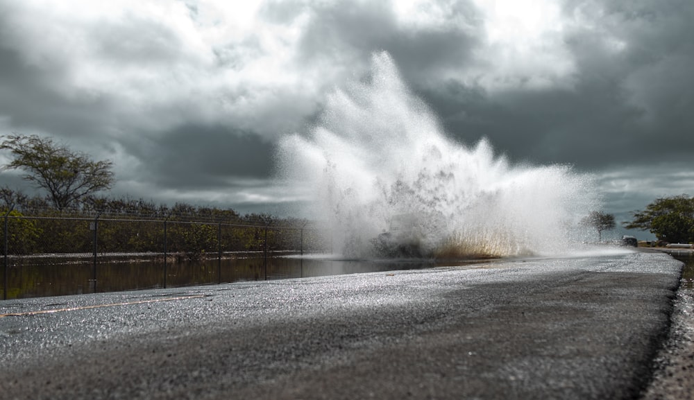 black asphalt road across water splash