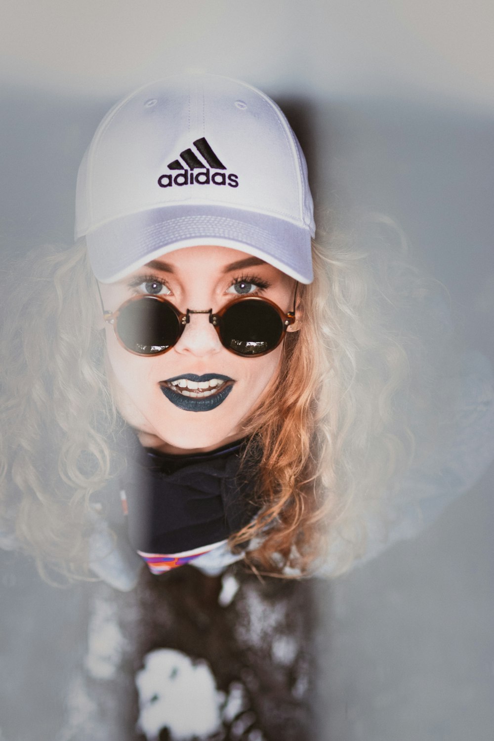 woman in black hoodie with white adidas fitted cap