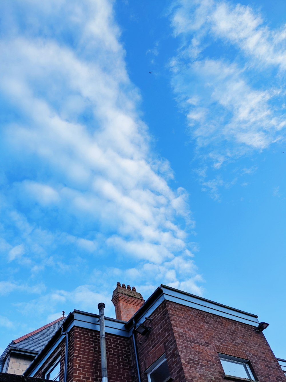 brown and black concrete building under white clouds and blue sky during daytime