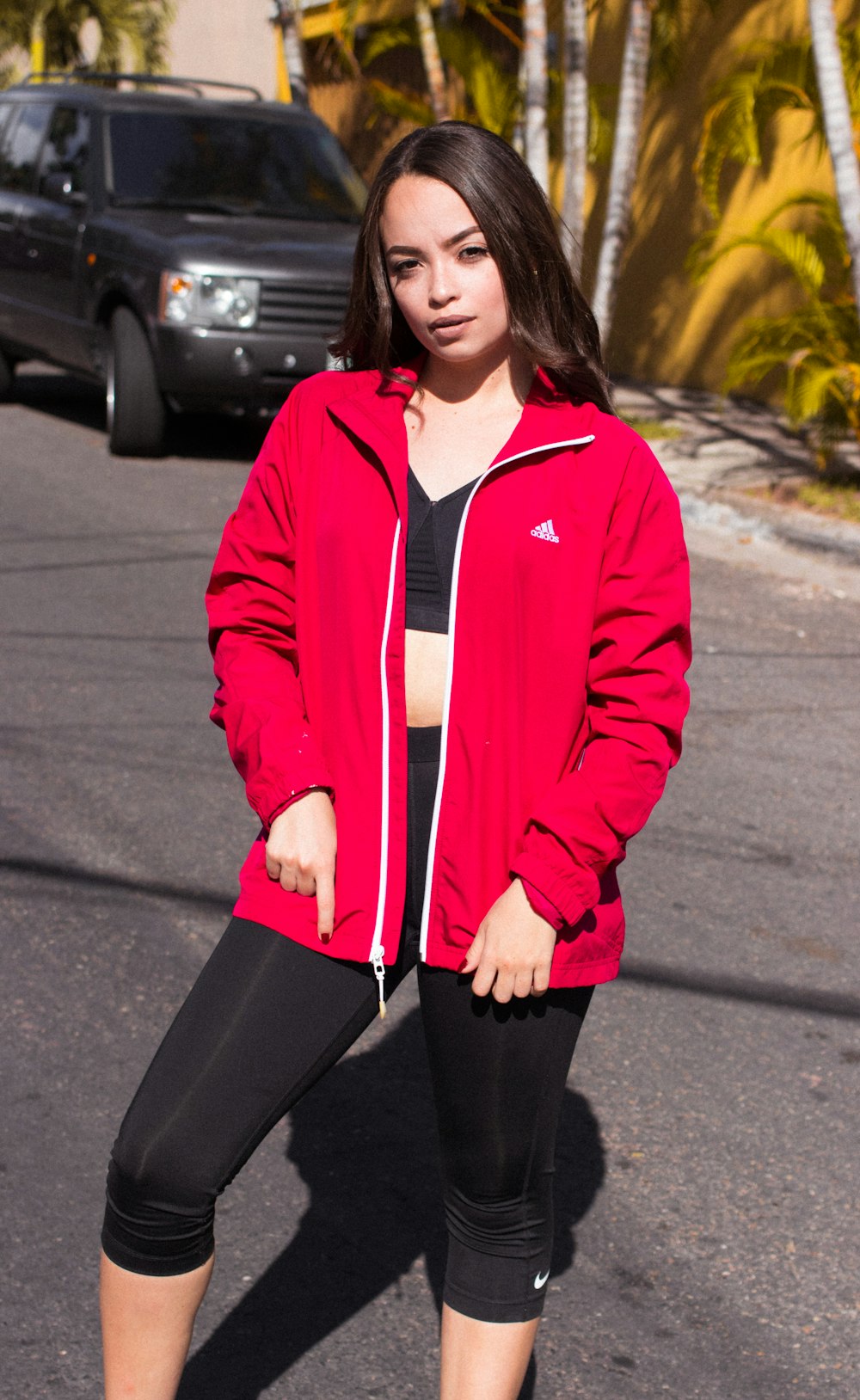 woman wearing red Adidas zip-up jacket and black leggings