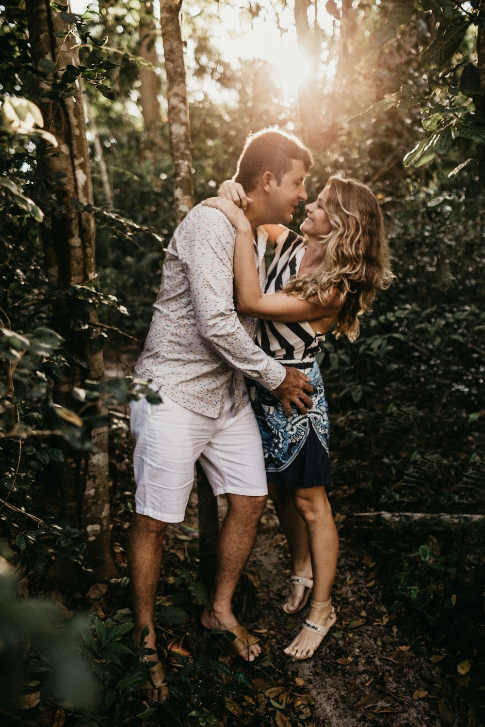 man and woman standing beside trees