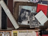 A collection of vintage items including old black and white photographs, a slide rule, and various documents in Russian, suggesting an historical or personal archive. The atmosphere is nostalgic and the objects are placed on a textured surface.