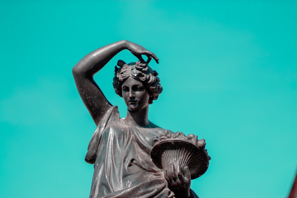 woman lifting hand over head sculpture