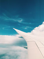 A panoramic shot of a jet soaring above the clouds, framed by a dusky sky with deep navy tones.