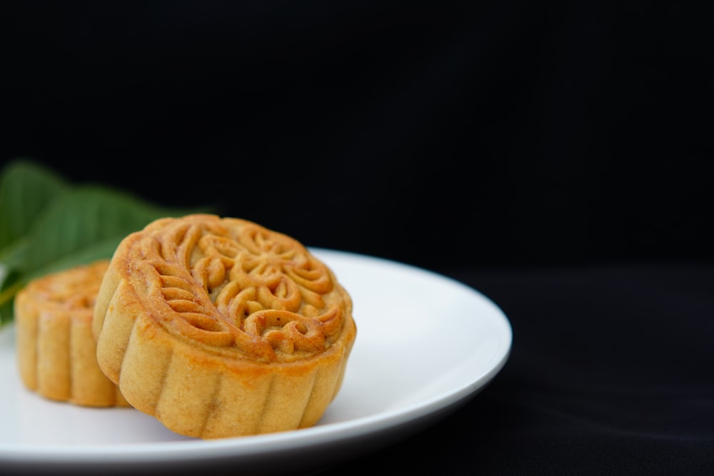 two moon cakes in white ceramic plate