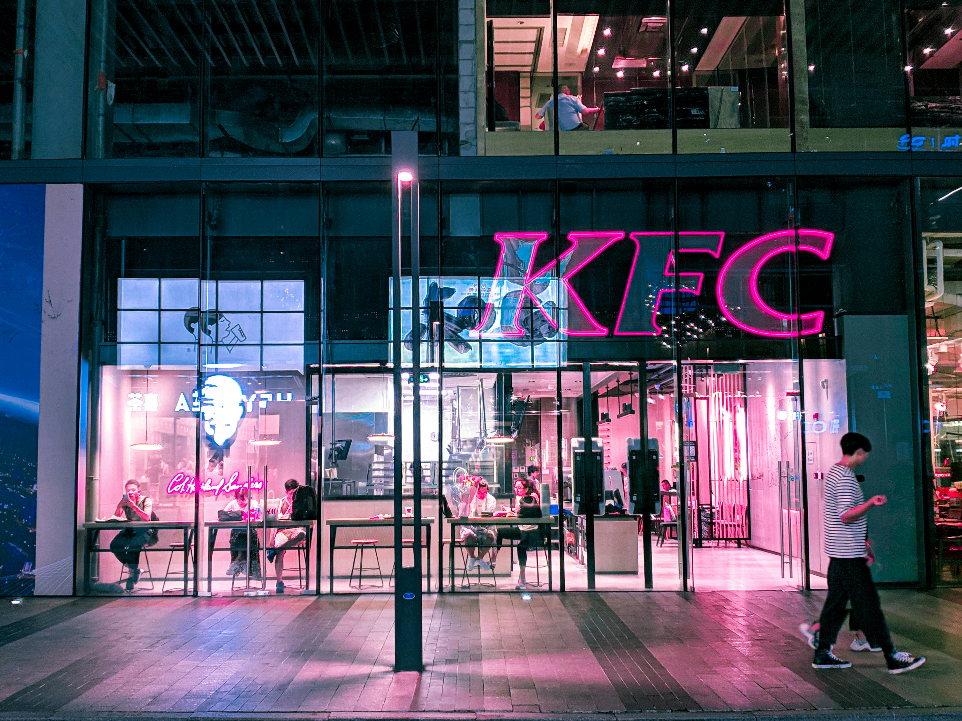 two person walking near KFC building during night time