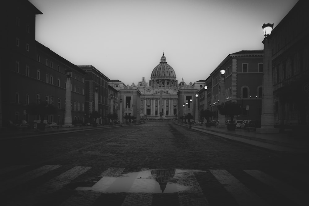 grayscale photography of road between houses