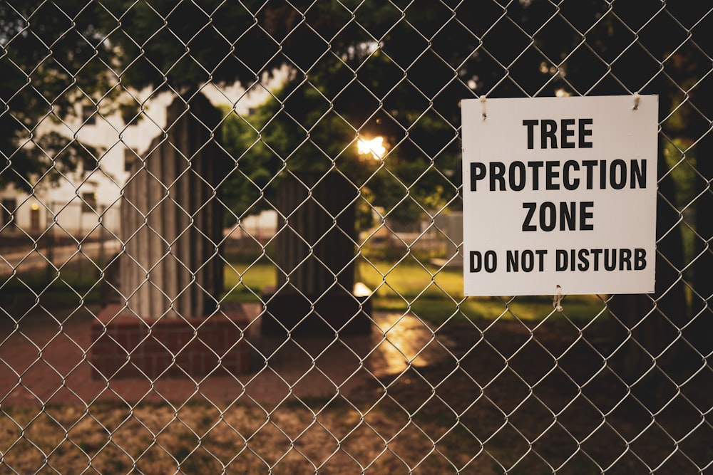 체인 링크 울타리에 매달려 있는 나무 보호 구역 보드