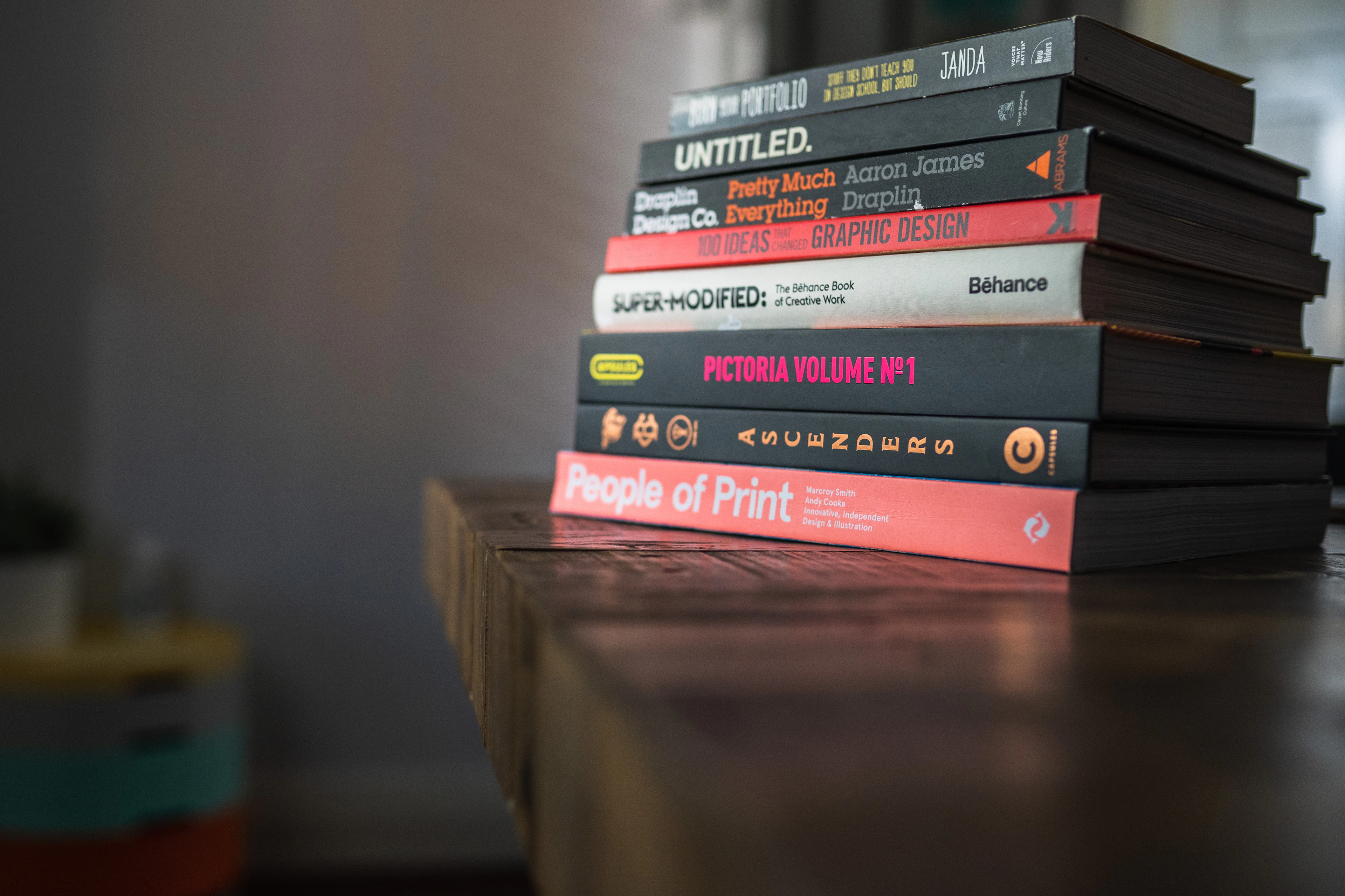 A stack of books with distinct titles on their spines, including one marked Untitled