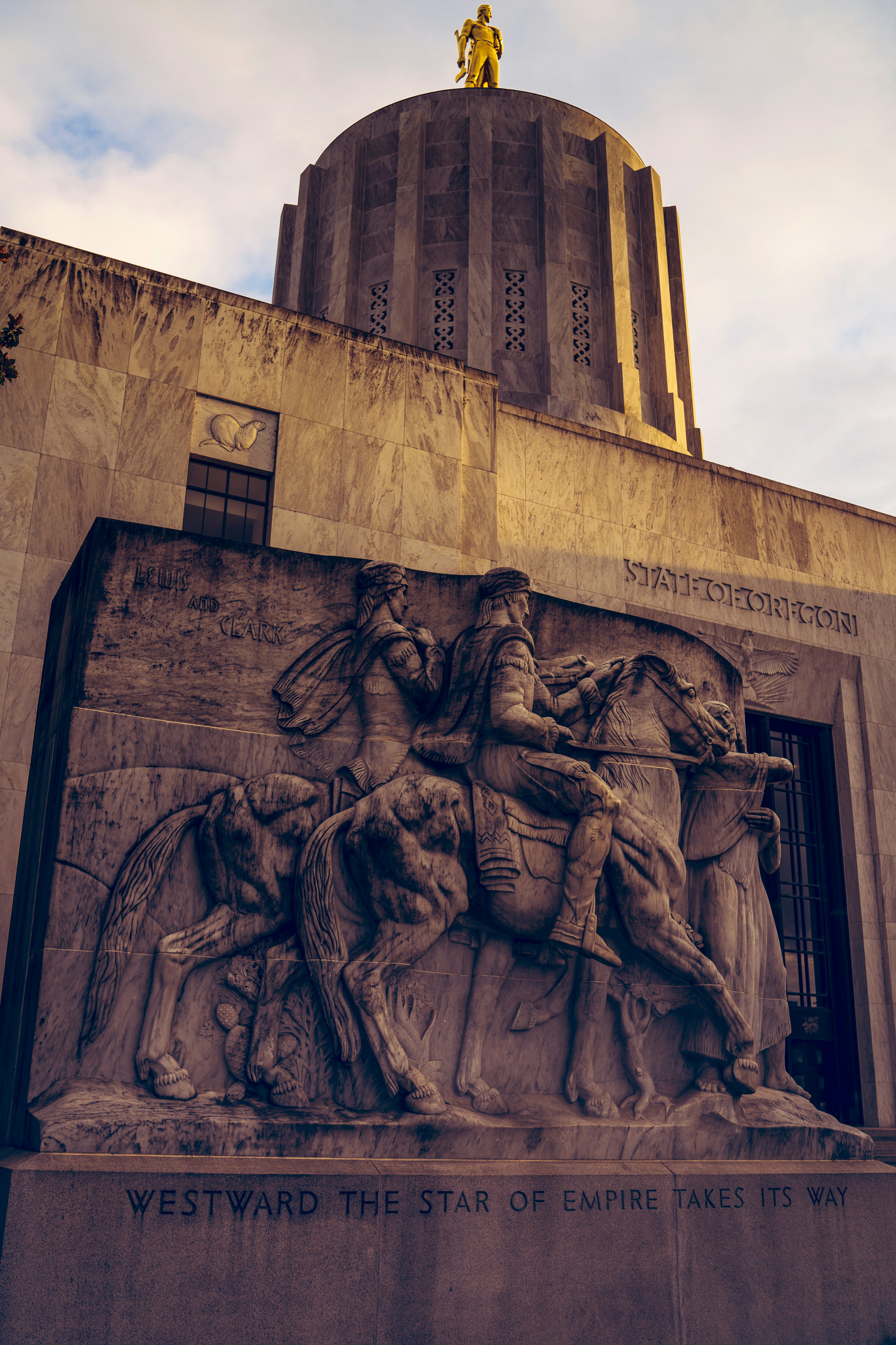 Since Oregon's capitol is in the news because some of our senators are throwing a tantrum over efforts to reduce greenhouse gas emissions...I decided to take a few photos of the building since I live a few blocks away. Without commenting on the subject of that sculpture itself, I was trying to capture the beautiful texture of the white marble in the late evening. And no photo of the Oregon Capitol Building is complete without the gold pioneer in frame.
