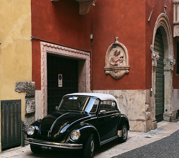 black Volkswagen Beetle near building