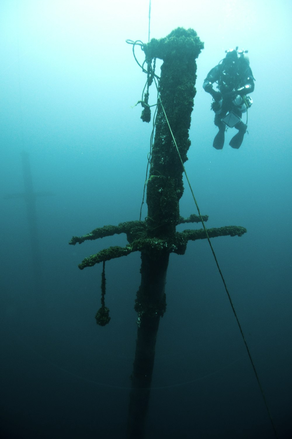 person wearing diving suit near sunken ship