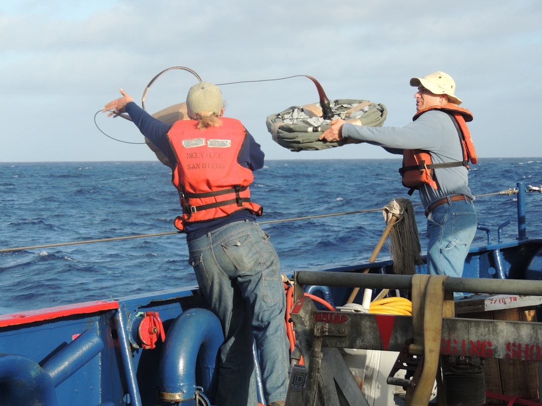 two men standing and throwing rope on sea, NOAA TAS onboard Scripps Institution of Oceanography Ship MELVILLE.