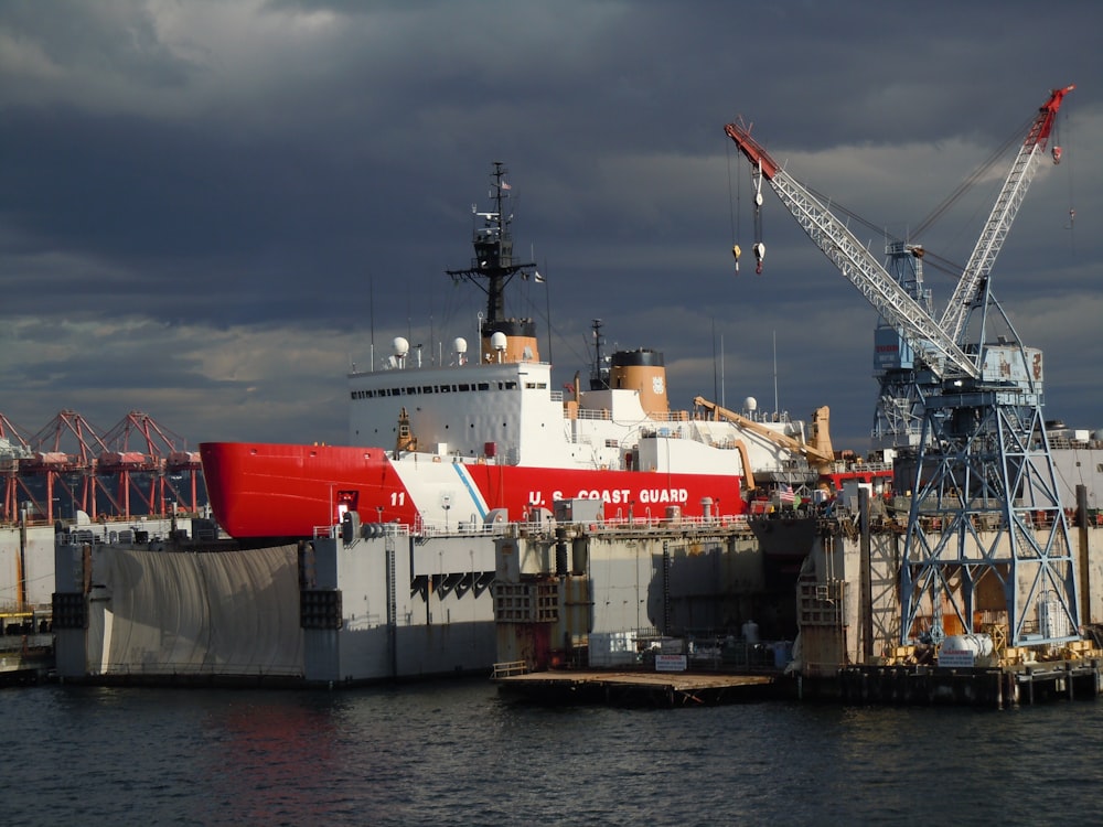 navio vermelho e branco perto do cais