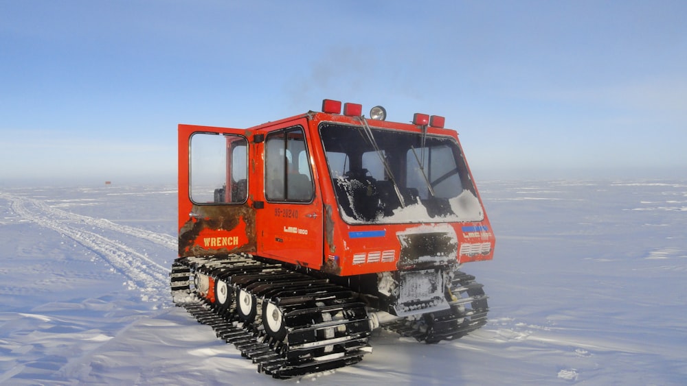 red and black vehicle on snowfield