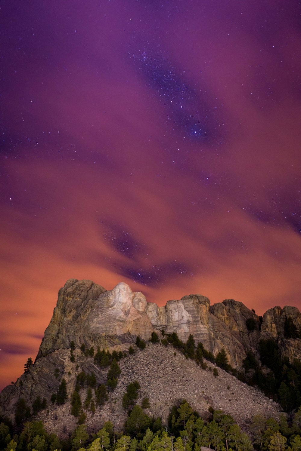 As estrelas atingem o pico através das nuvens no Monte Rushmore