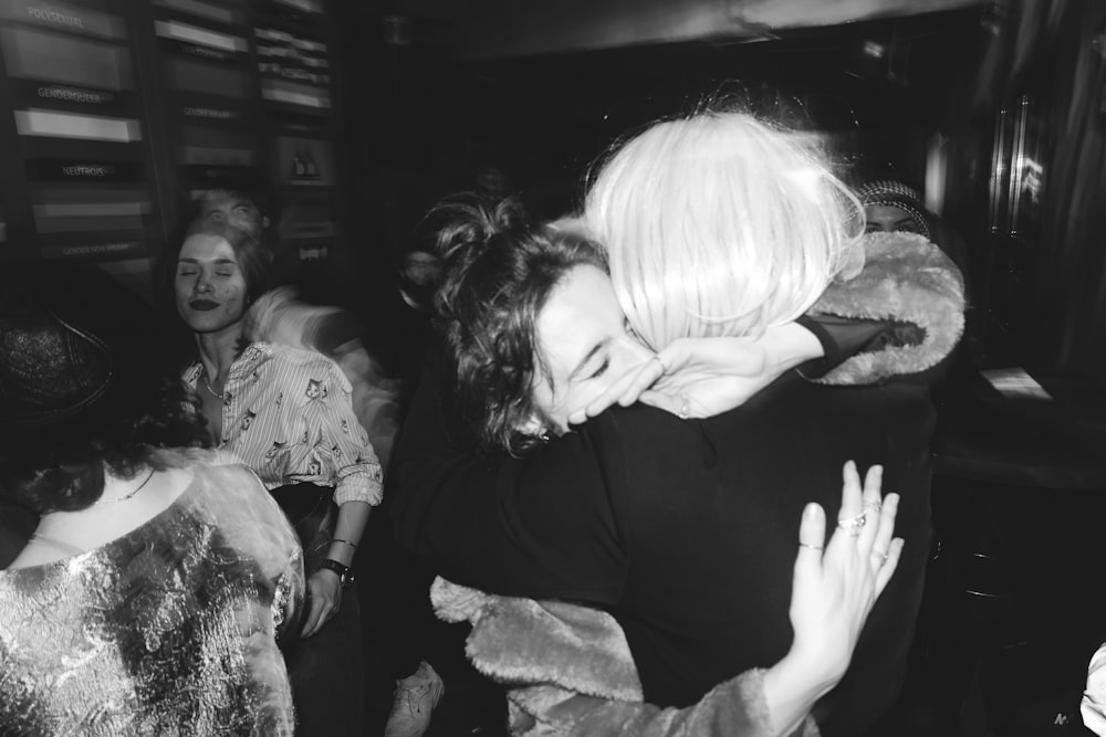 a woman hugging another woman in a crowd