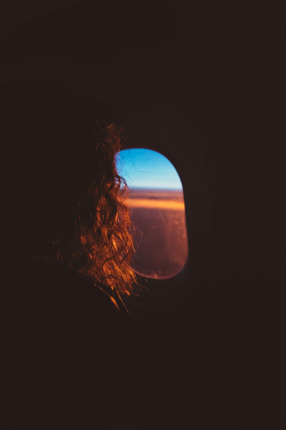 飛行機の窓から外を見ている女性