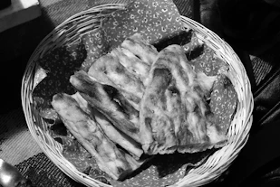Close-up of freshly made injera with its spongy texture on a traditional woven basket.