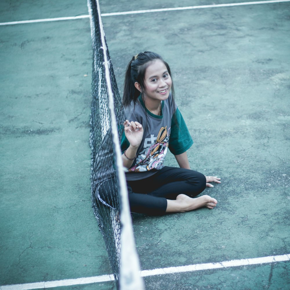 woman sitting on tennis court
