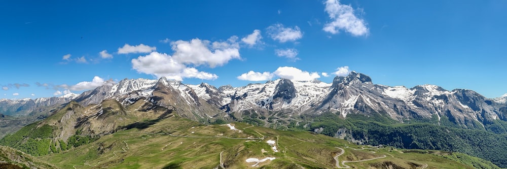 snow-covered mountain under white clouds and blue sky