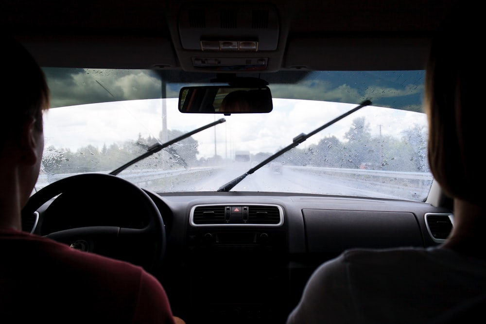 two people in car on wet road in rainy day