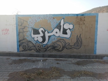 A vibrant street mural in Arabic calligraphy capturing a powerful quote.