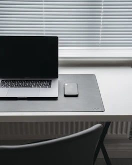 Minimalistic workspace with a smartphone showing an email app, emphasizing professional communication.