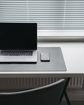 A clean, modern desk showing a smartphone with a privacy app open, surrounded by simple tech accessories.