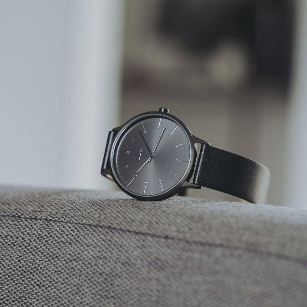 selective focus photography of black analog watch with black strap