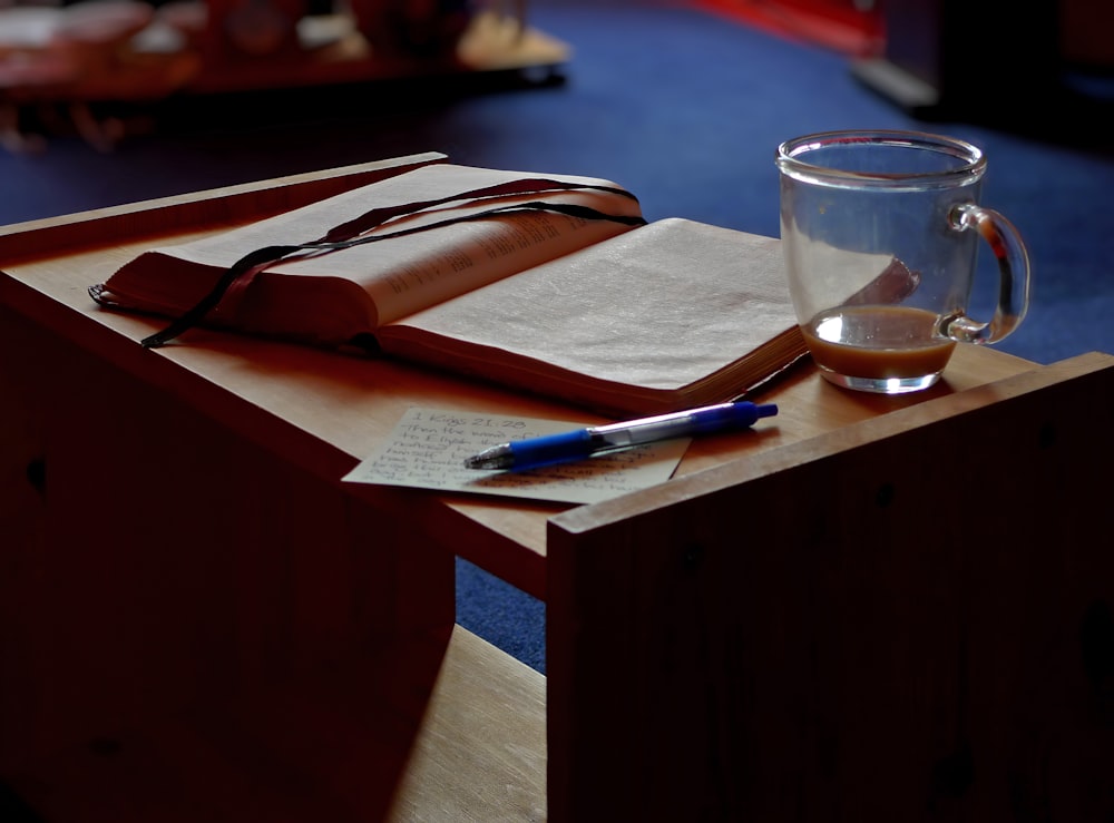 clear glass mug beside book