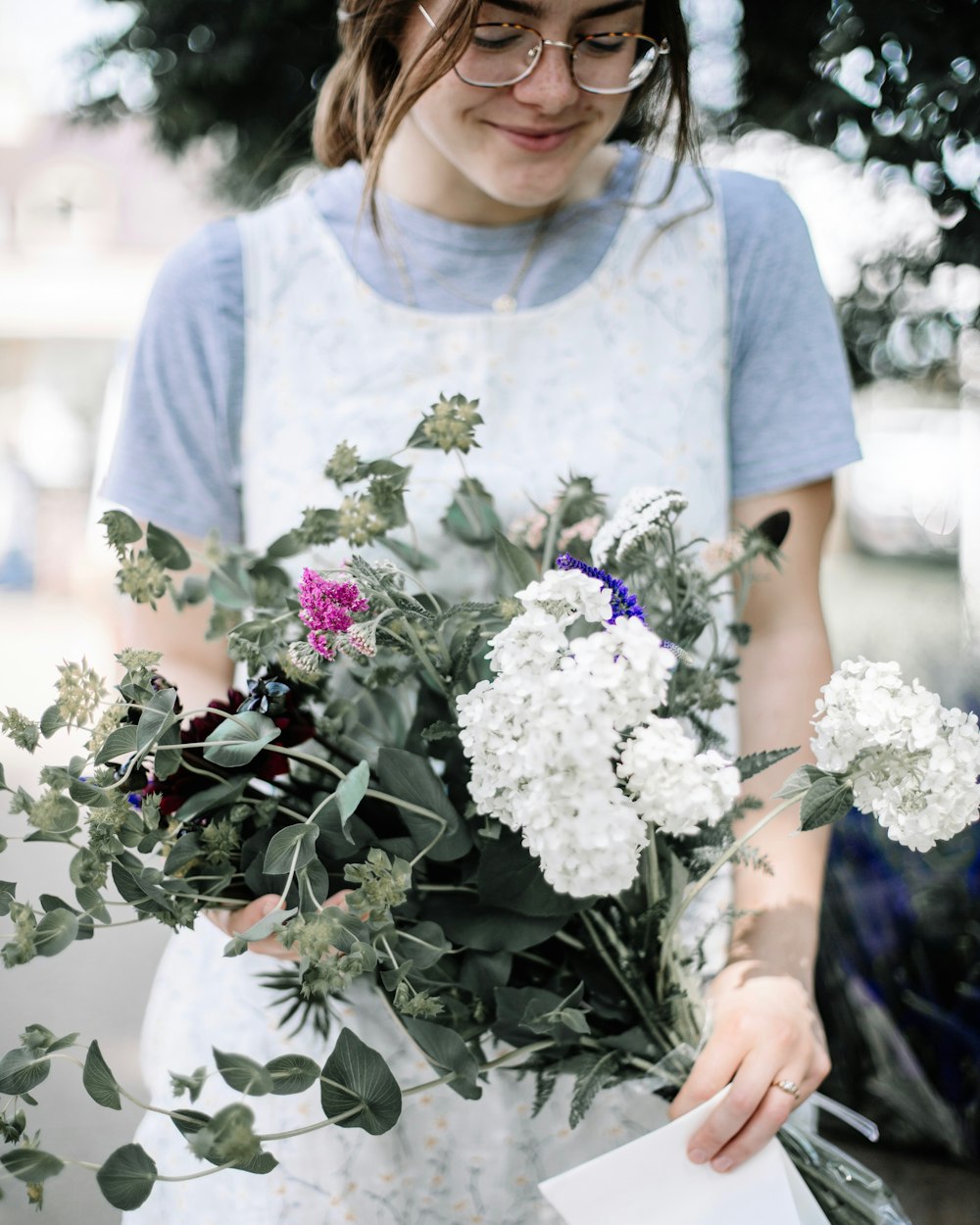 woman smiling and looking downwards while holding flowers