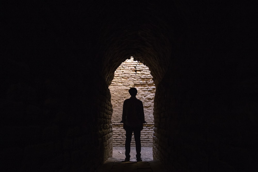 silhouette of man under arch hallway