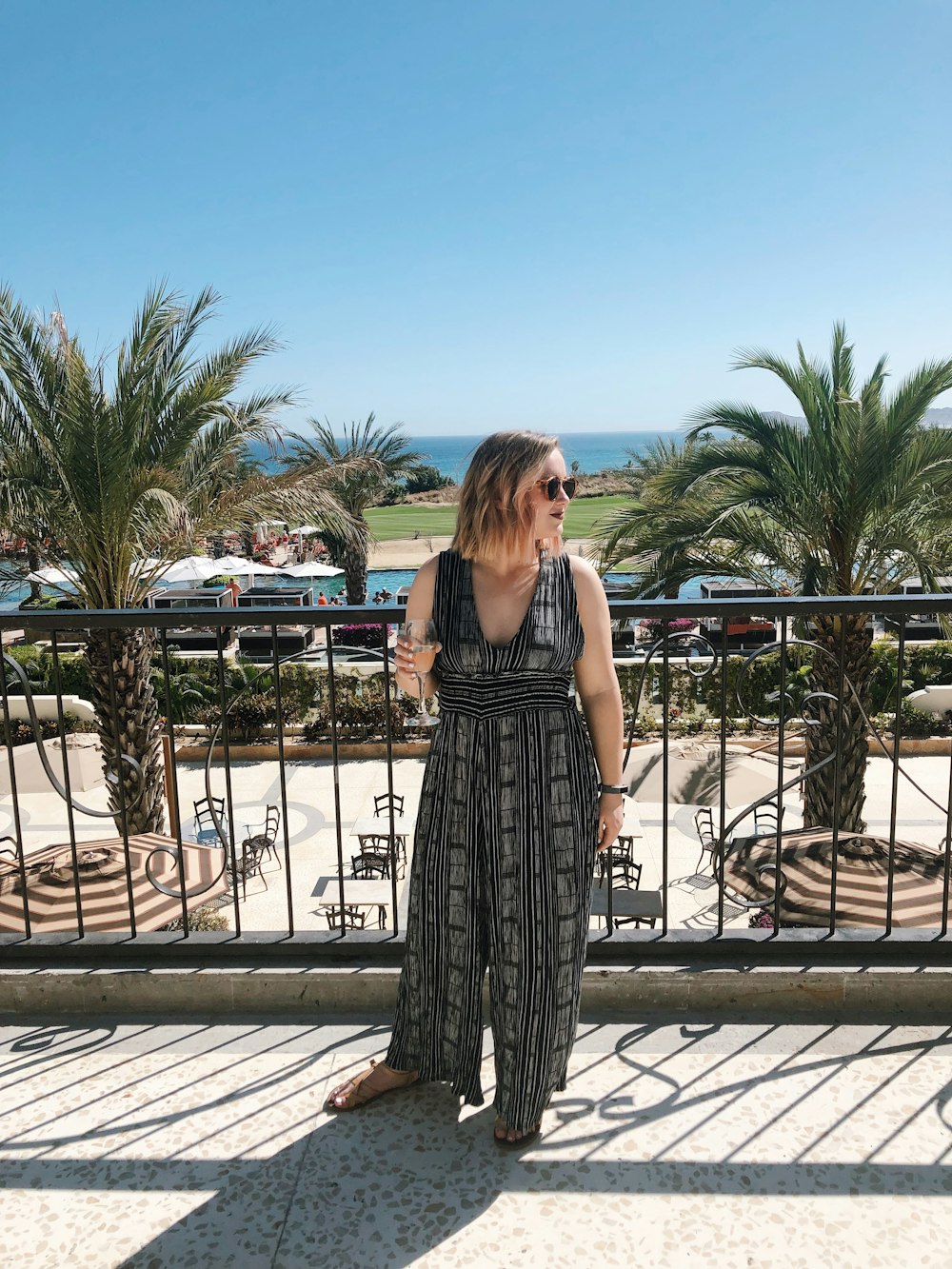 woman in black overalls standing in front of black metal railings