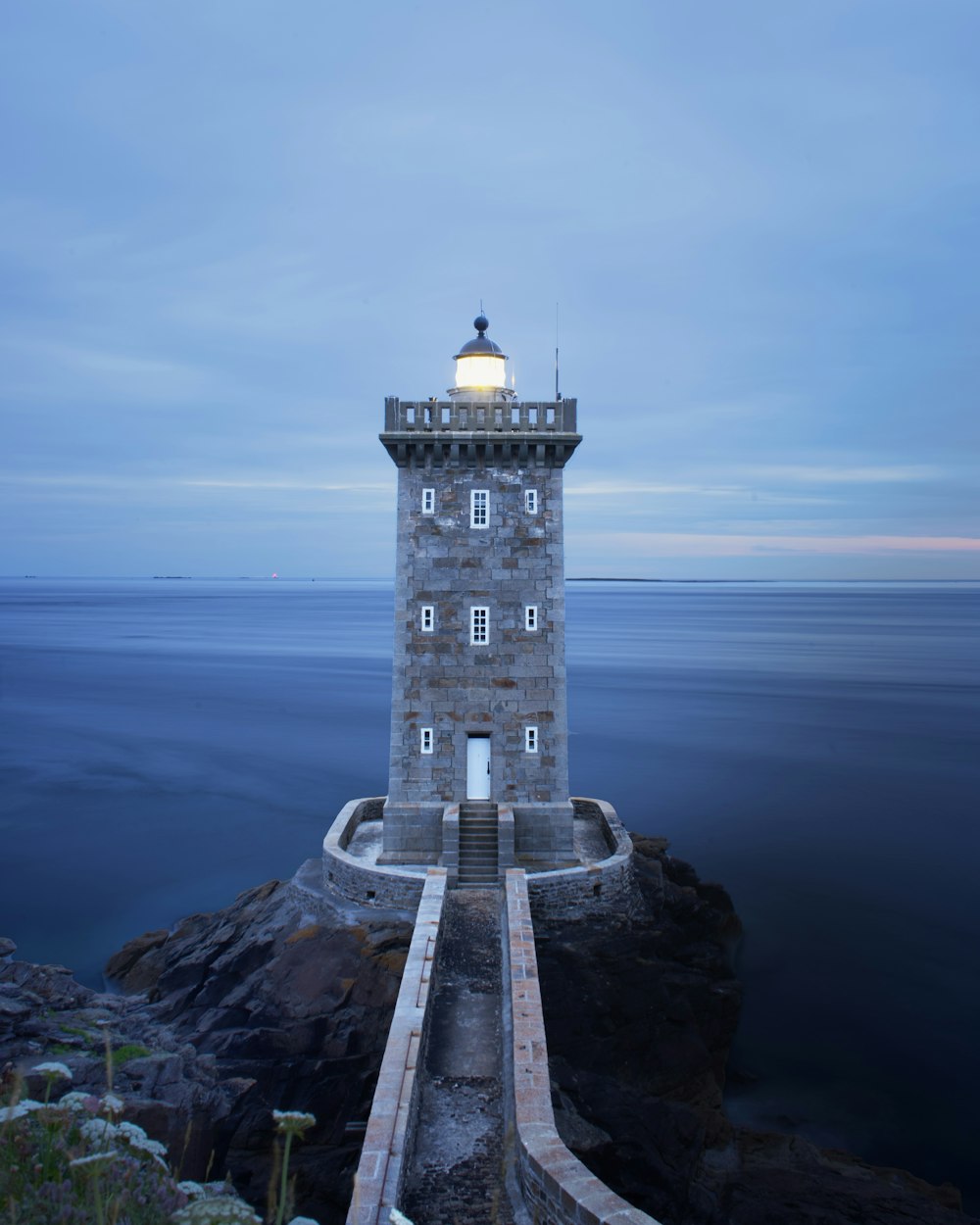 brown lighthouse near body of water during daytime