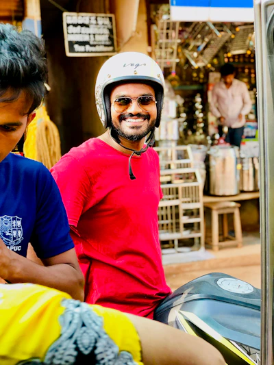 A happy customer proudly sitting on their new red sport motorcycle in front of the Motoventa store.