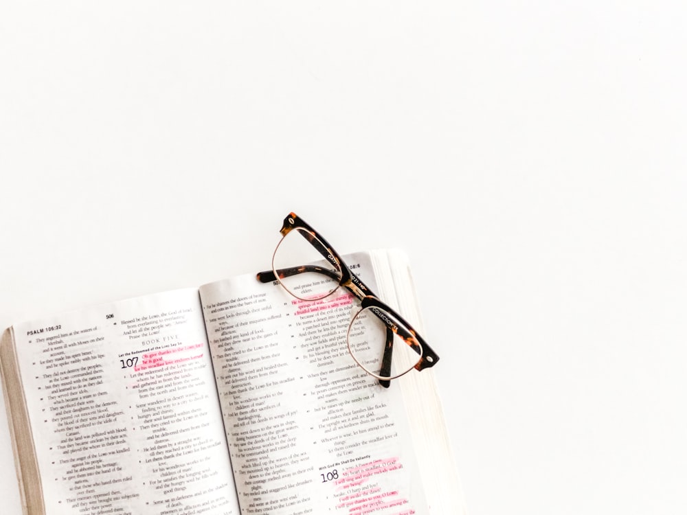 Clubasmter-style eyeglasses on open book